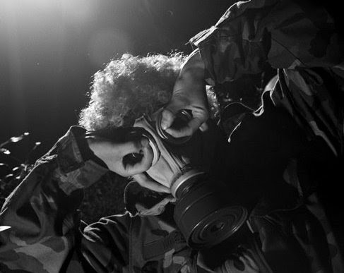 Person adjusting a gas mask in black and white